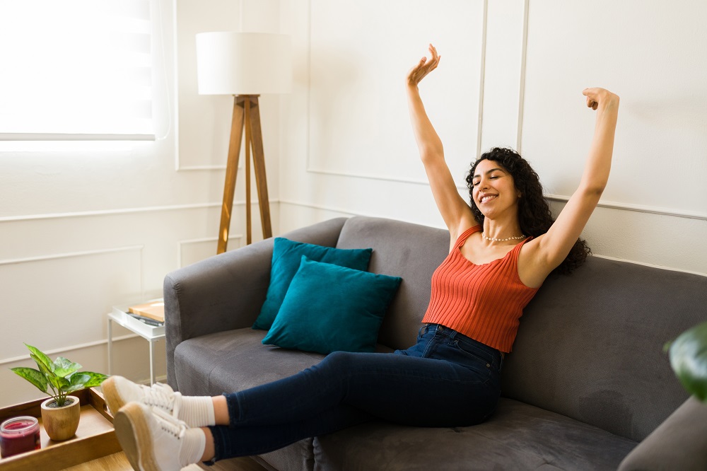 Frau-sitzt-gluecklich-und-ohne-Blasenprobleme-durch-Magnesiummangel-am-Sofa